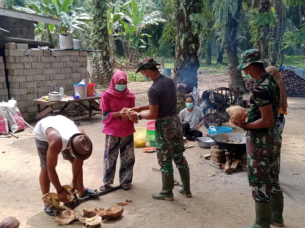 Disela-sela Kegiatan TMMD, TNI Bantu Warga Kupas Kelapa