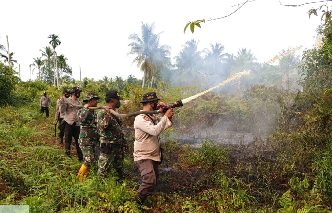 Polsek Kuala Kampar Lakukan Pendinginan Titik Api di Desa Sungai Solok